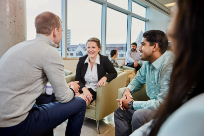 Telfer students talking while sitting in the Desmarais Building.