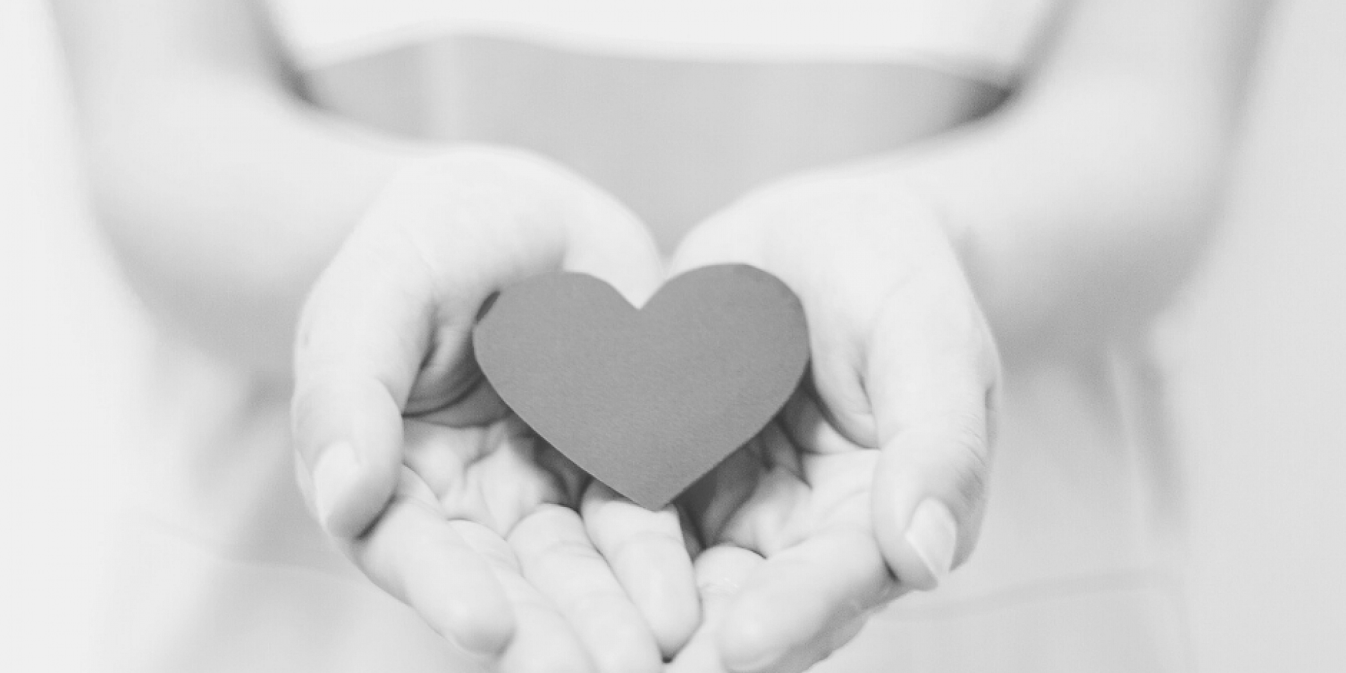 Hands holding a paper-shaped heart 