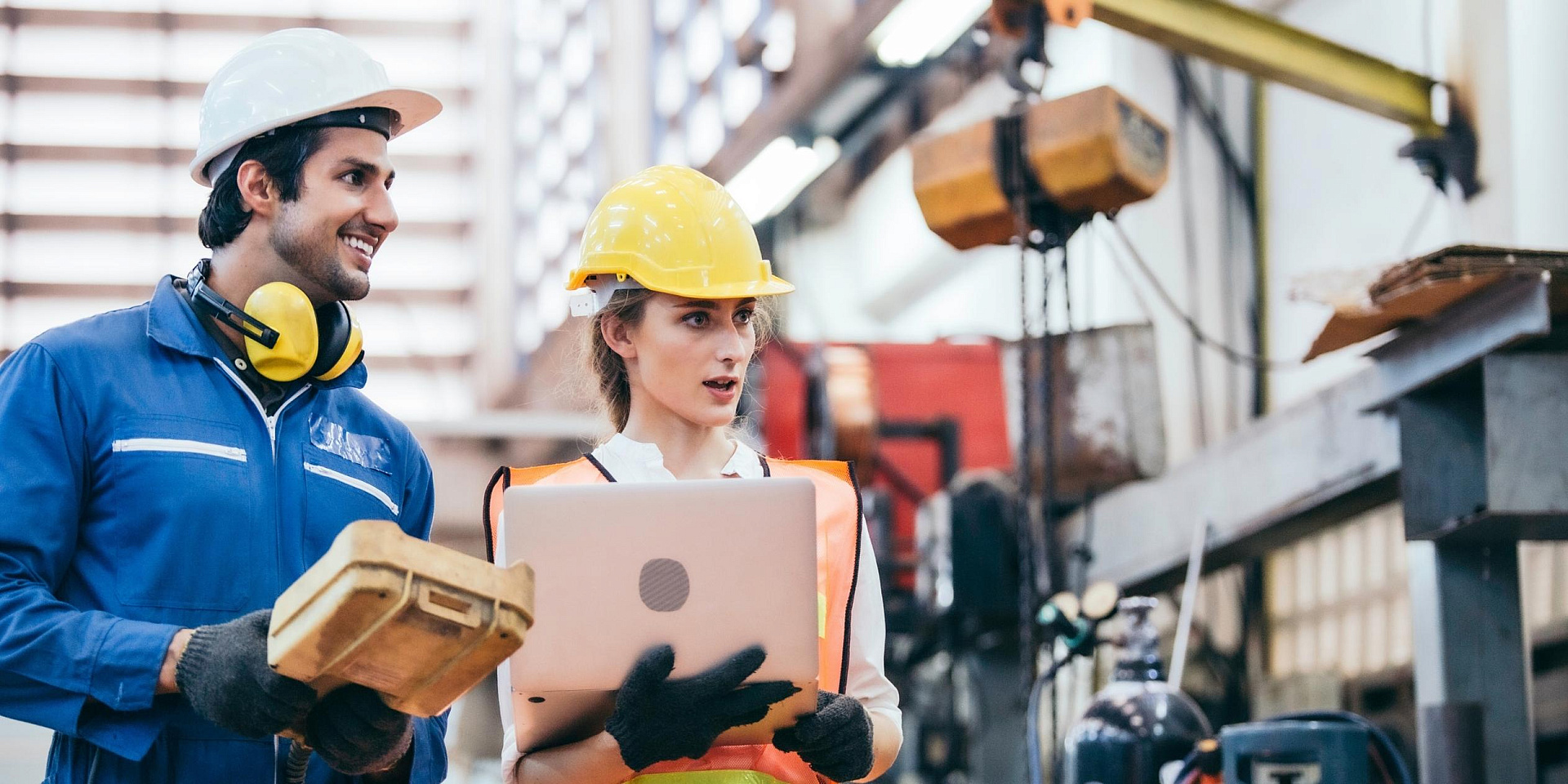 Une femme et un homme discutent d'un projet sur un chantier de construction