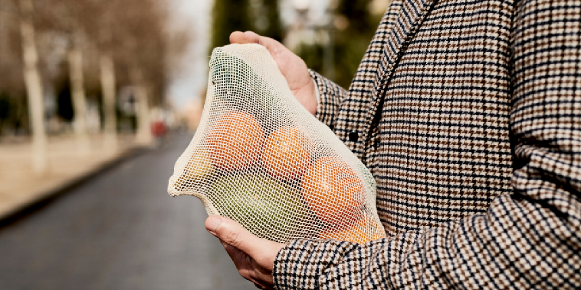 Femme qui tient entre ses mains un sac réutilisable remplis de fruit